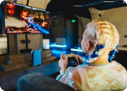 Een meisje speelt op een spelcomputer voor een groot tv-scherm
